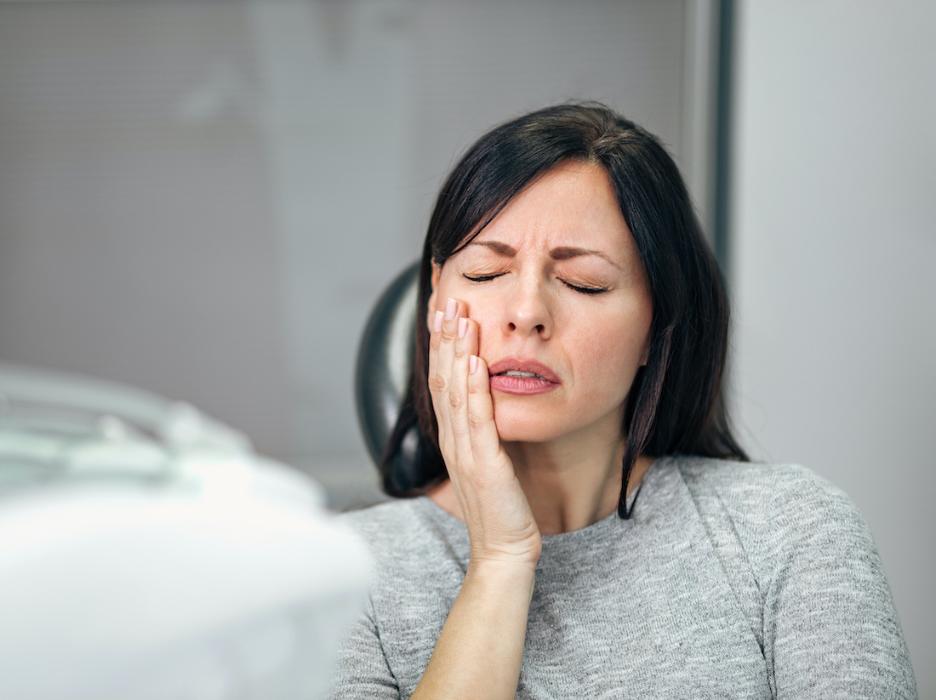 Woman holding her mouth in pain, charlotte nc