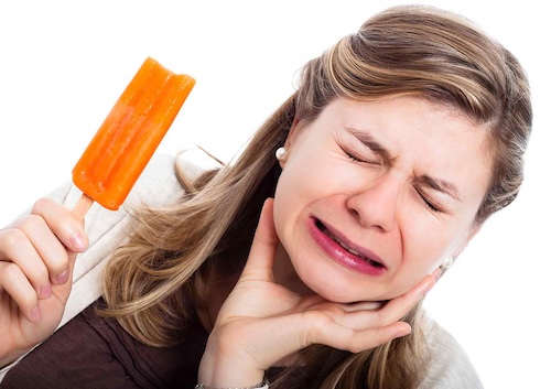 Woman holding popsicle in tooth pain