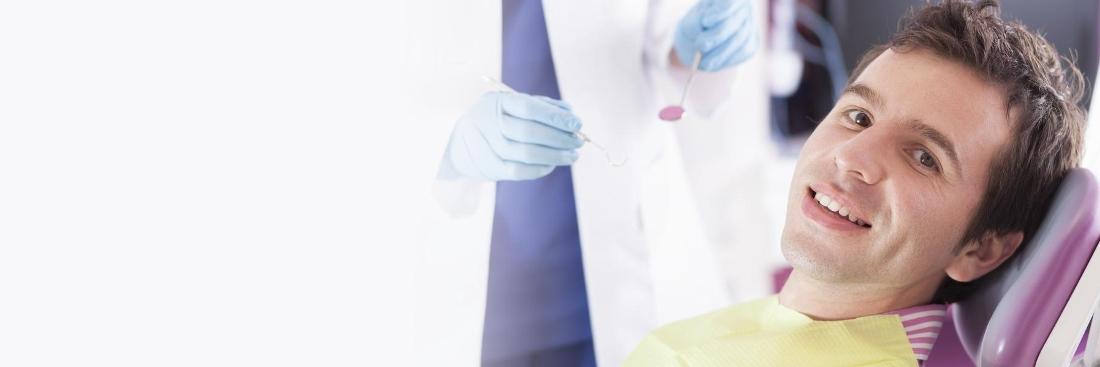 young dark haired man sitting nervously in a dentist chair