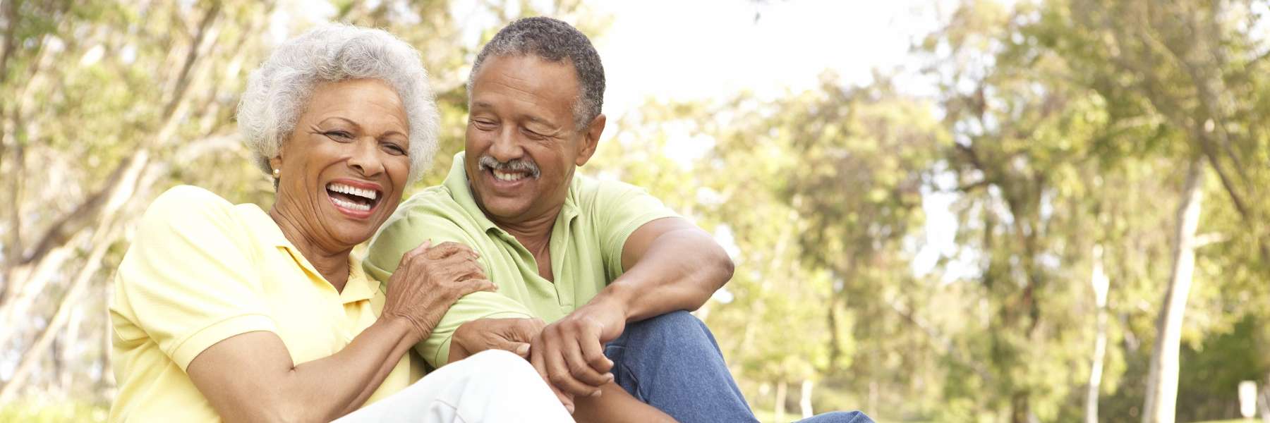 An older couple laughing in the park