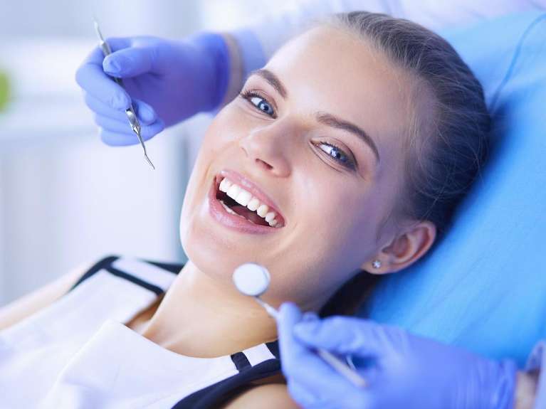 A smiling woman receiving a dental exam