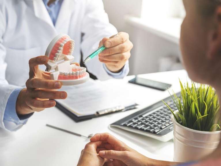 Dentist pointing at tooth diagram to a patient, charlotte nc