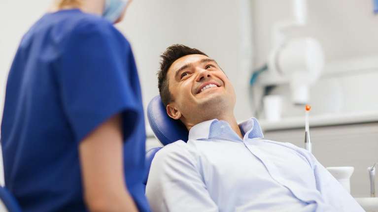 A man smiling during a dental exam