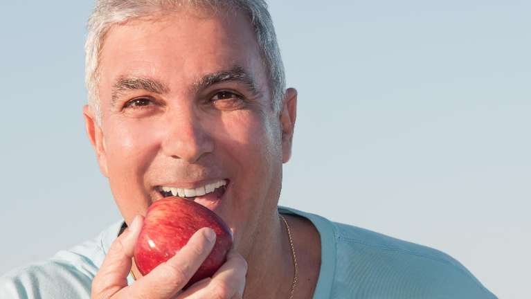 A man eating an apple | Holistic dentist in Charlotte NC