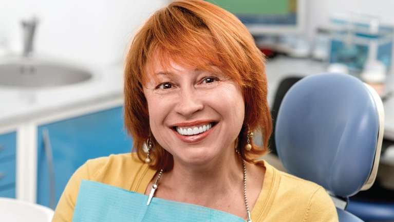 A smiling woman getting a dental cleaning