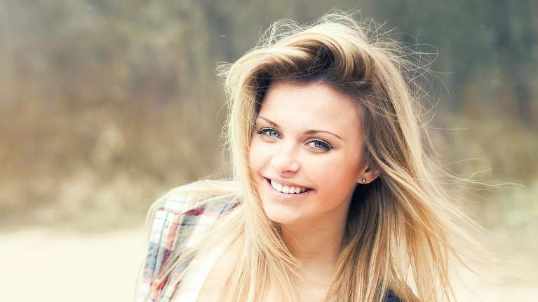 A smiling woman outdoors | Dentist in Charlotte