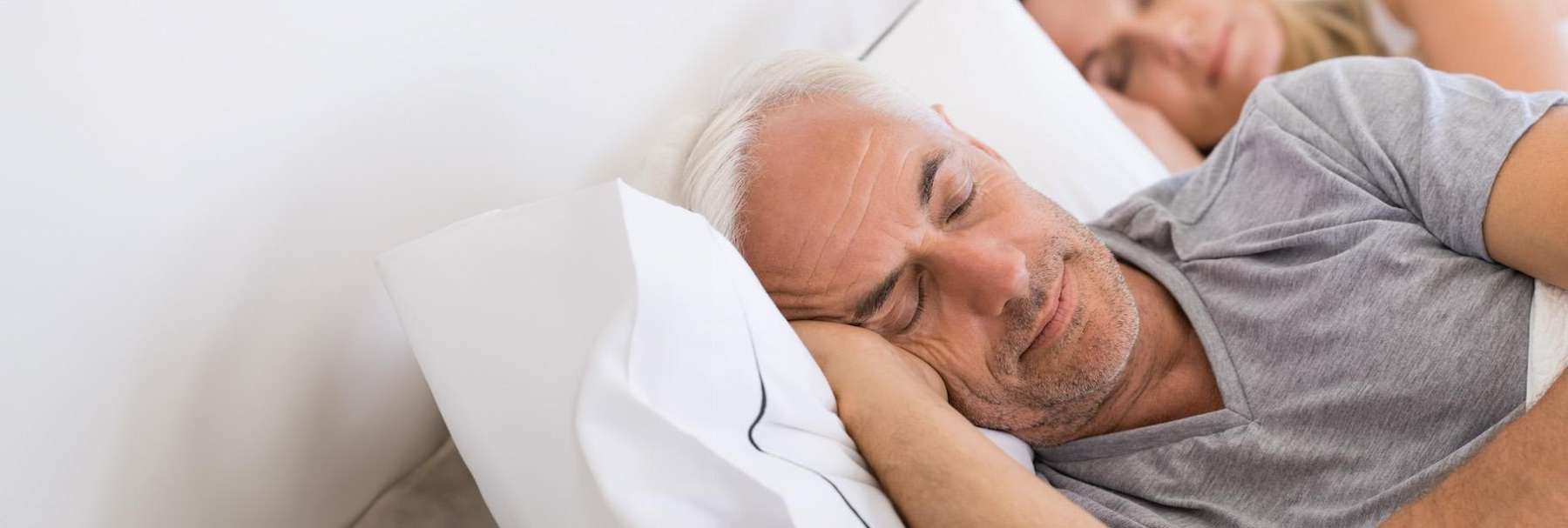 Older man sleeping on a pillow smiling, charlotte nc